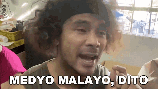 a man with curly hair is making a funny face with the words medyo malayo dito written below him