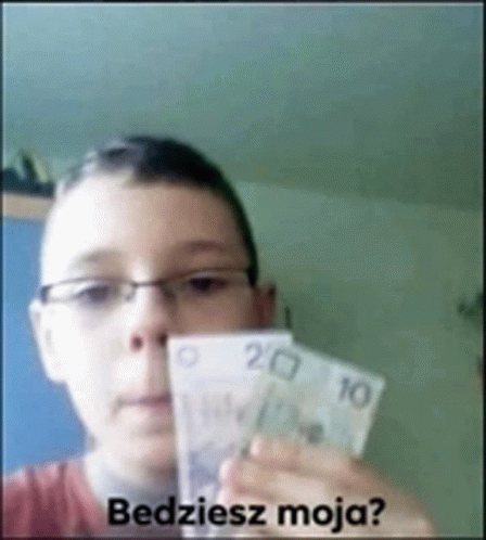 a boy wearing glasses is holding a bunch of money in front of his face and the words " bedziesz moja " are visible