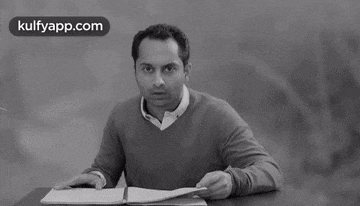 a black and white photo of a man sitting at a table with the words kulfyapp.com on the bottom