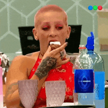 a woman with a shaved head is eating a piece of cake