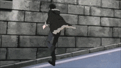 a man in a black coat is running in front of a brick wall .