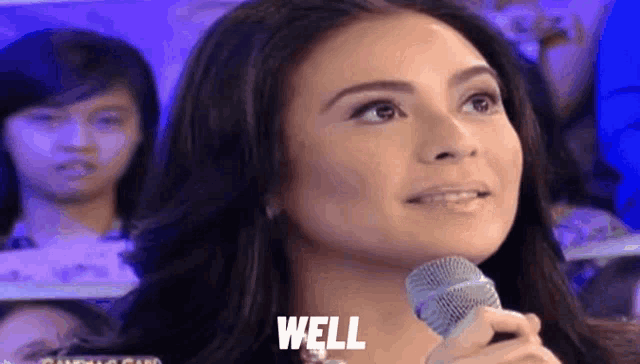 a woman is holding a microphone and the word well is above her