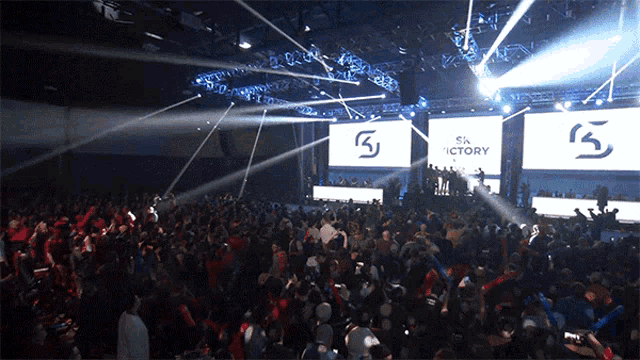 a crowd of people are gathered in front of a large screen that says victory