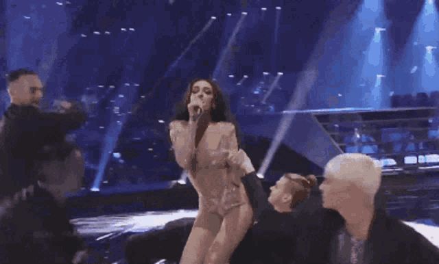 a woman is singing into a microphone on a stage and the words dare to dream are on the bottom