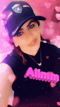 a woman wearing a black hat and a black shirt with the word alimy on it