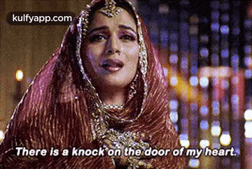 a woman in a veil is crying and saying `` there is a knock on the door of my heart . ''