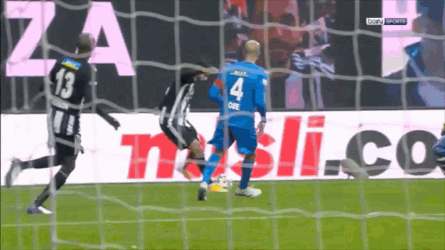 a soccer player with the number 4 on his jersey kicks the ball