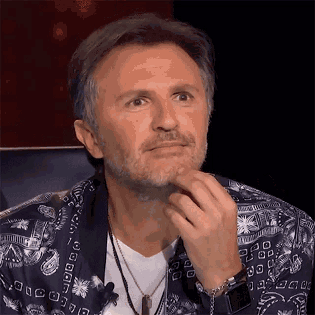 a man with a beard wearing a bandana jacket and a watch