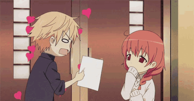 a boy is giving a piece of paper to a girl who is looking at it