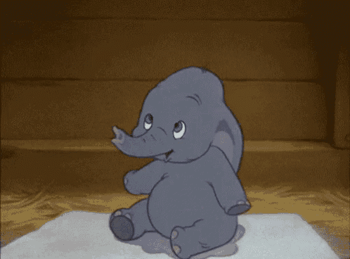 a baby elephant is sitting on a piece of paper with its trunk up .