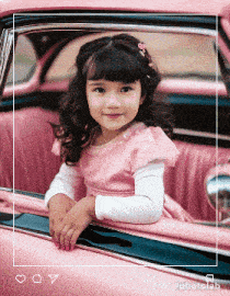 a little girl is sitting in a pink car