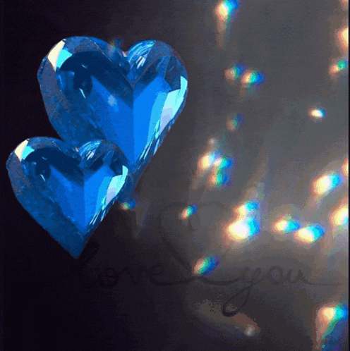 two blue hearts on a dark background with the words love you in the corner