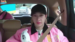 a woman in a pink jacket is sitting in the back seat of a car holding a teddy bear .