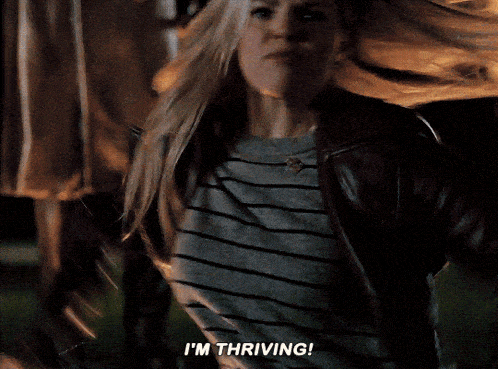 a woman is screaming and saying i 'm thriving in front of a blurry background