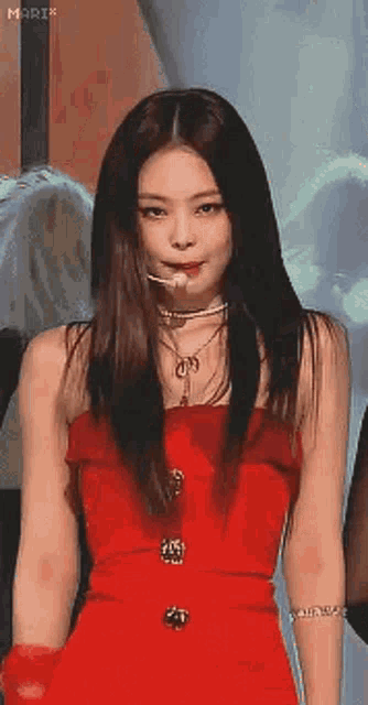 a woman in a red dress is standing in front of a crowd .