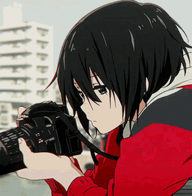 a girl in a red jacket is holding a camera