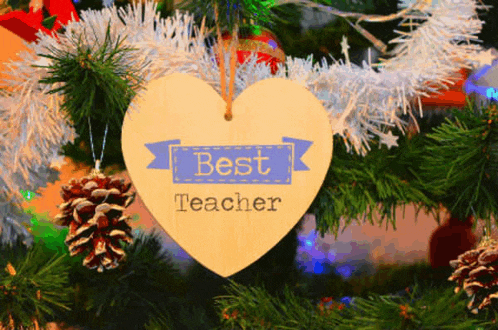 a heart shaped ornament on a christmas tree says " best teacher "