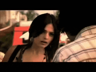 a woman is standing next to a man in a plaid shirt and looking at him .