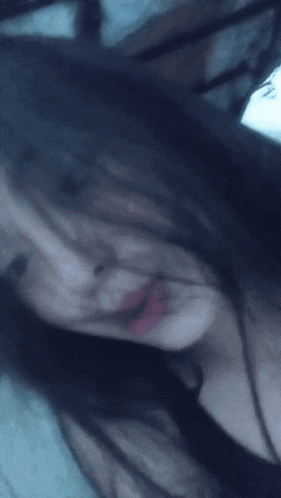 a close up of a woman 's face with long black hair