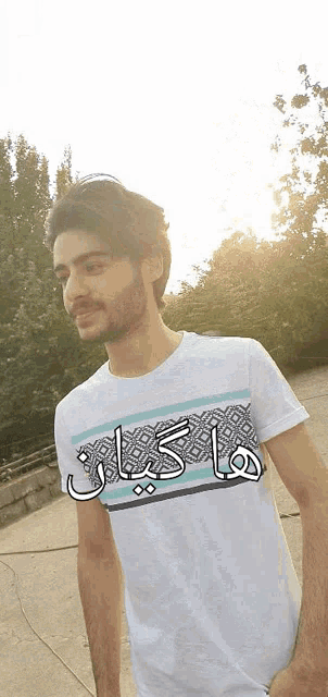 a man wearing a white t-shirt with arabic writing on the front