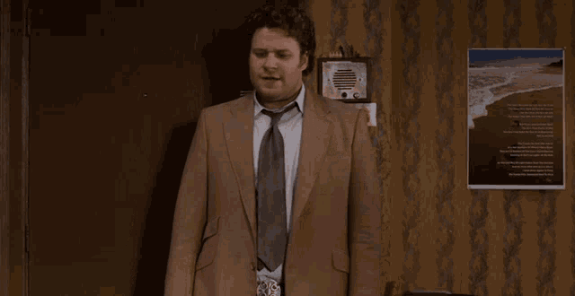 a man in a suit and tie says i 'm in in a room