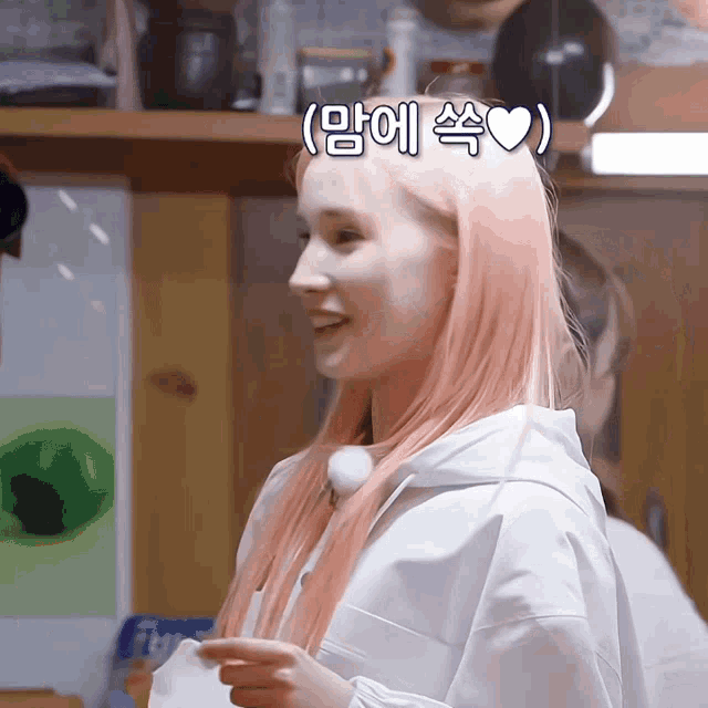 a woman with pink hair has a heart on her head in korean