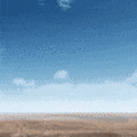 a blue sky with a few clouds and a sandy beach in the foreground