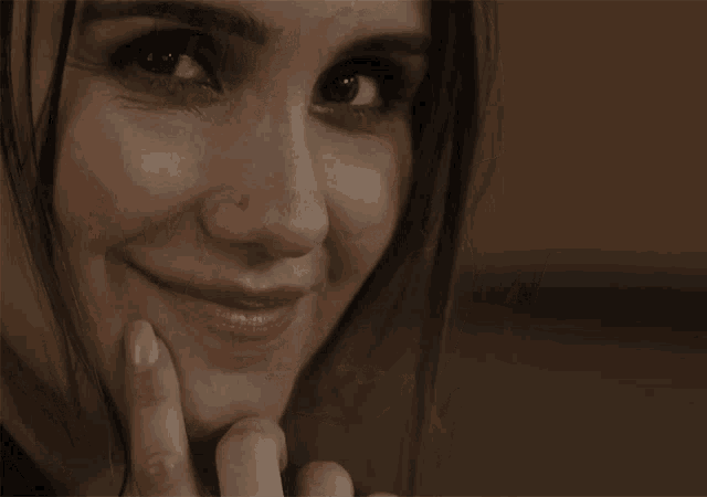 a close up of a woman 's face with a slight smile on her face