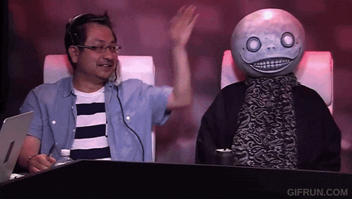 a man in a striped shirt sits next to a man with a mask on his head that says gifrun.com on it