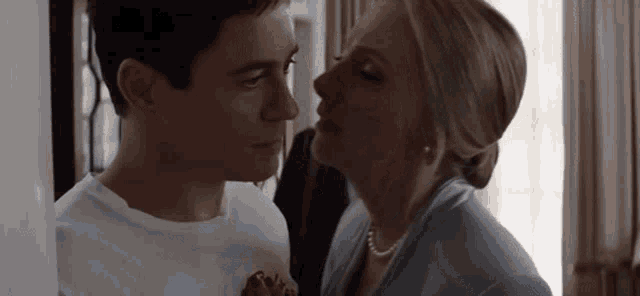 a man and a woman are kissing in a room