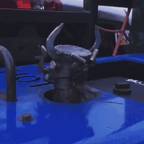 a skull with horns is sitting on top of a blue car