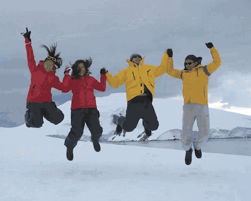 three people jumping in the air with their arms in the air