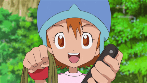 a girl in a blue hat is holding a cell phone in her hand