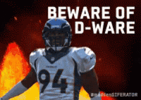 a football player with the number 94 on his jersey stands in front of flames