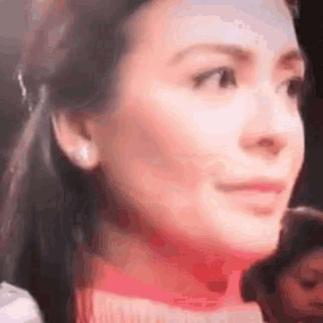 a close up of a woman 's face with a blurred background .