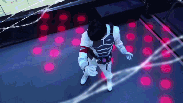 a man in a superhero costume is standing in a room with a lot of red lights