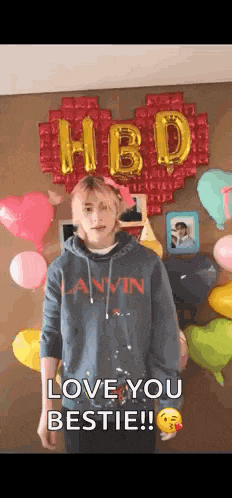 a woman in a hoodie is standing in front of balloons and balloons .