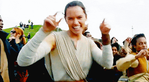 a woman is dancing in front of a crowd of people while giving a thumbs up .