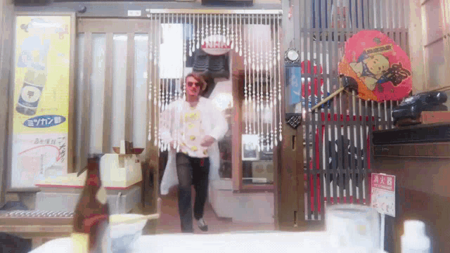 a man is walking into a store with a sign that says nhk