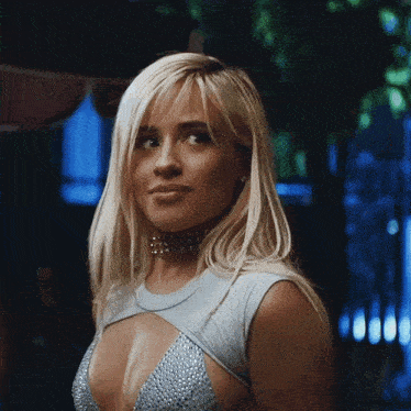 a woman with blonde hair is wearing a choker and a very low cut top