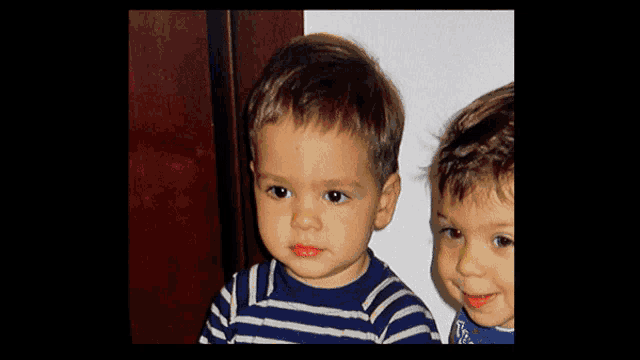 two young boys wearing blue and white striped shirts