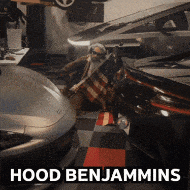 a man in a hood benjamins costume holds an american flag in a garage