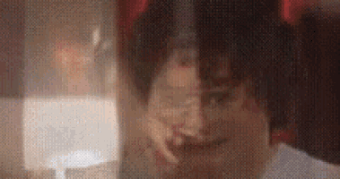 a close up of a person 's face with a blurred background and a lamp in the background .