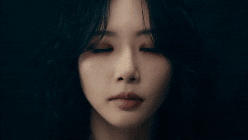 a close up of a woman 's face with dark hair