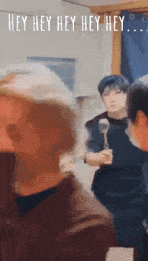 a group of people are standing in a room with the words hey hey hey hey