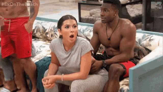 a man and a woman are sitting on a couch and the man is holding the woman 's hand .
