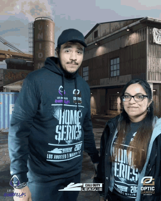 a man and a woman pose for a photo in front of a call of duty league background