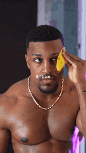 a shirtless man is applying a yellow sponge to his face and the time reads 8:45 am