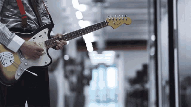 a man is playing a fender electric guitar