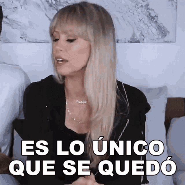 a woman sitting on a couch with the words es lo unico que se quedo